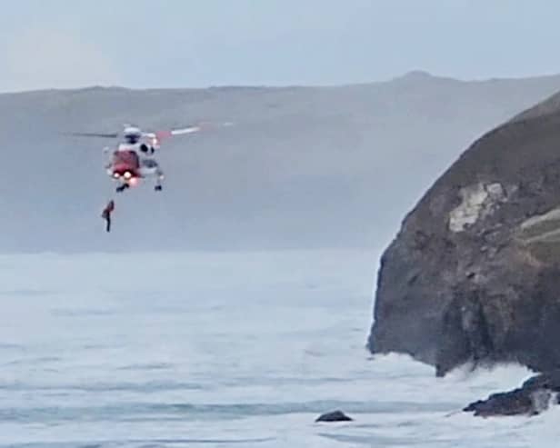 Footage capturing a dog walker being airlifted to safety after falling from a coastal path in Cornwall.  