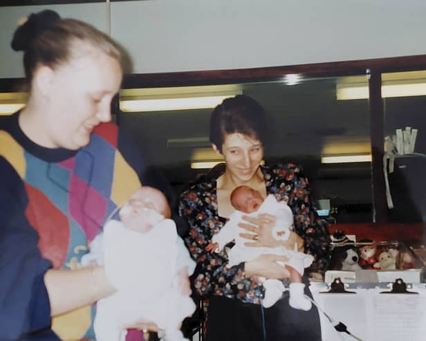Bronwyn is held by mum Debbie as a baby, and Jack is held by mum Sharon.