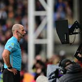 Referee Tim Robinson checks the on-field VAR screen after a penalty shout for Brighton at Crystal Palace