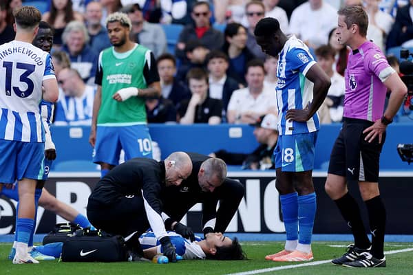 Brighton winger Kaoru Mitoma receives treatment on a hamstring injury