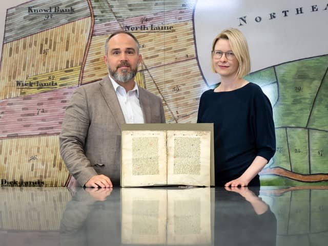 Dr Katie Walter and Dr James Wade in The Keep archive, Brighton, with the fragment of Nicholas Love’s early 15th-century Mirror of the Blessed Life of Jesus Christ_Credit_  Courtesy of the University of Sussex