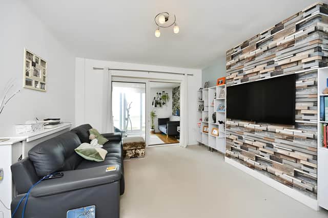 The generous lounge leads into a sun room with glass doors opening onto the front balcony