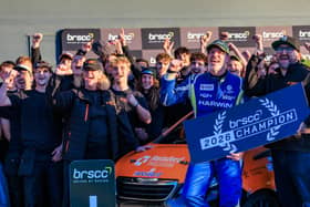 The TNR team celebrating stood around the car.