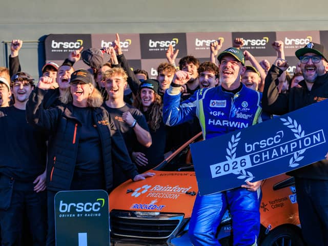 The TNR team celebrating stood around the car.