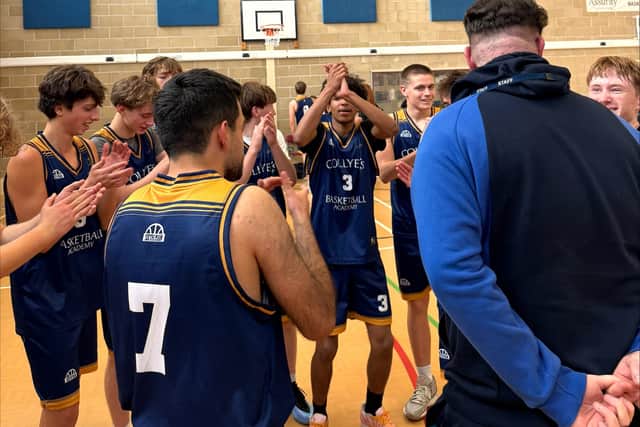 Coach Evans is applauded by his team after the game
