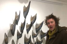 Artist Leigh Dyer with the metal fins being exhibited by At Sea, George Street, Hastings