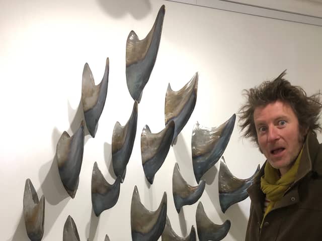 Artist Leigh Dyer with the metal fins being exhibited by At Sea, George Street, Hastings