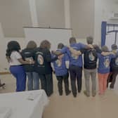 Delegates showing the back of their t-shirt with the inscription - Humanity: Inspire a Kinder World