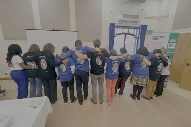 Delegates showing the back of their t-shirt with the inscription - Humanity: Inspire a Kinder World