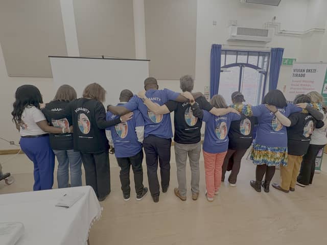 Delegates showing the back of their t-shirt with the inscription - Humanity: Inspire a Kinder World
