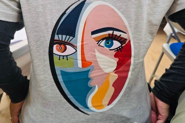 A delegate showing the back of their t-shirt with the inscription: Humanity - Inspire a Kinder World.