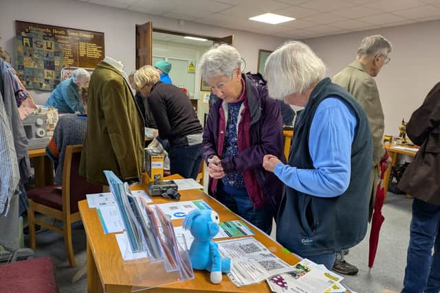 A visitor learning about SHARE, our local Library of Things, at New Leaf