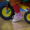  A toddler rides a trike.