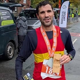 Lewes AC’s Ben Peters celebrates his marathon medal after conquering the wind, rain and muddy trails to finish second overall.