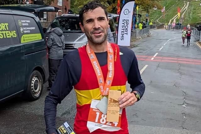 Lewes AC’s Ben Peters celebrates his marathon medal after conquering the wind, rain and muddy trails to finish second overall.