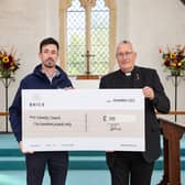 Jake Priddle (Marketing Manager at BRICS) hands over the cheque to Reverend Stephen Davies (Rector of Earnley Church)
