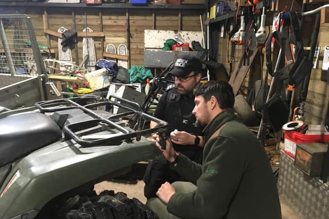 Sergeant Tom Carter, Sussex Police operational lead for Wildlife, Heritage and Environmental Crime, marking up vulnerable equipment at Ashdown Forest with ranger Michael Payne