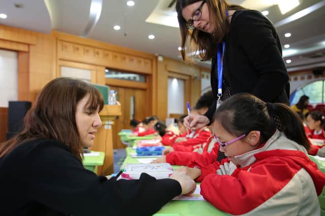 Melanie Squires, left, and Michelle Cannon working with children in Shanghai