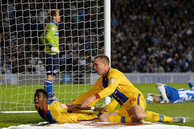 Wilfried Zaha of Crystal Palace celebrates with team-mate Aaron Wilbraham after scoring his first goal during the Championship play off semi final second leg at Brighton in  2013