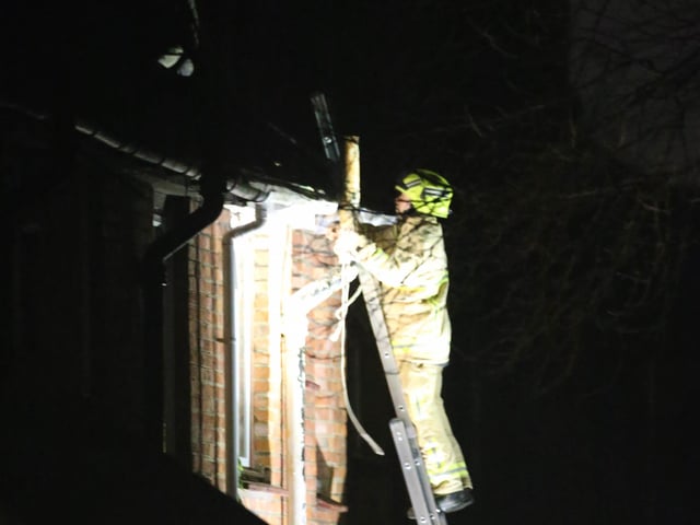 A firefighter bravely confronted the man after reaching the roof of the house.