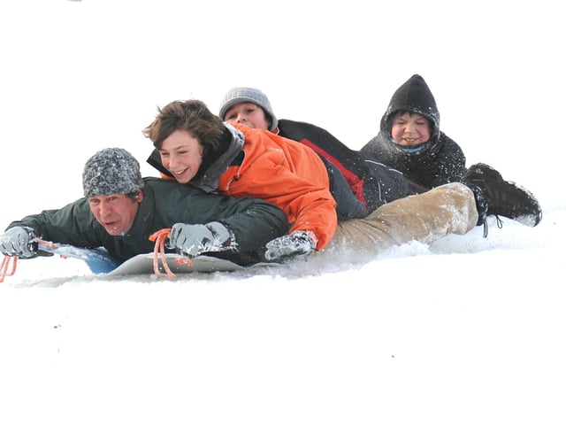 Hurtling down the hill having fun on just a plastic sheet.