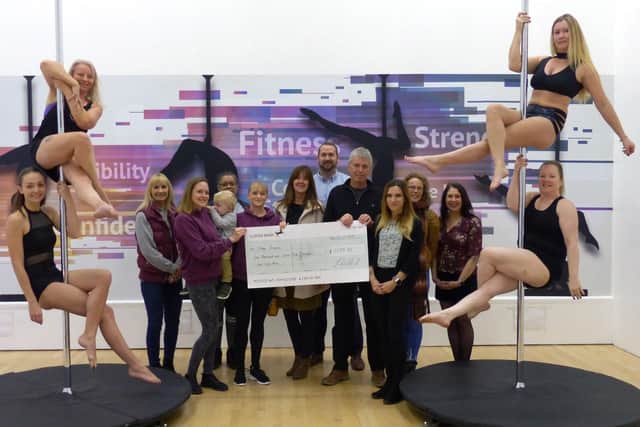 Pole fitness enthusiasts presenting the cheque to the GreenDreams Festival events team