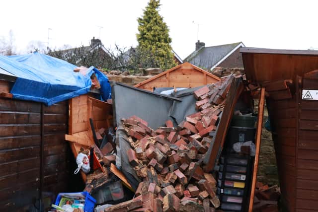 A wall felled by Storm Brendan smashed into sheds in Horsham