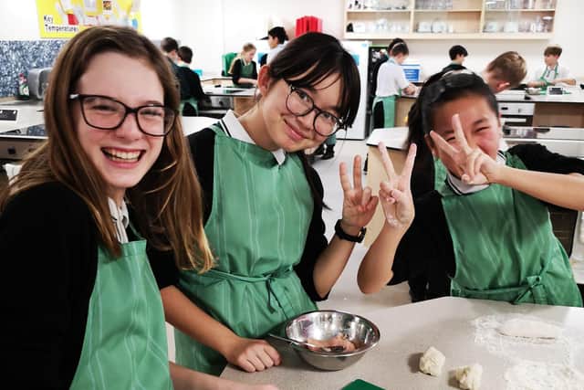 Megan Perry, Anna Hu, and Domenika Panyamark making dumplings