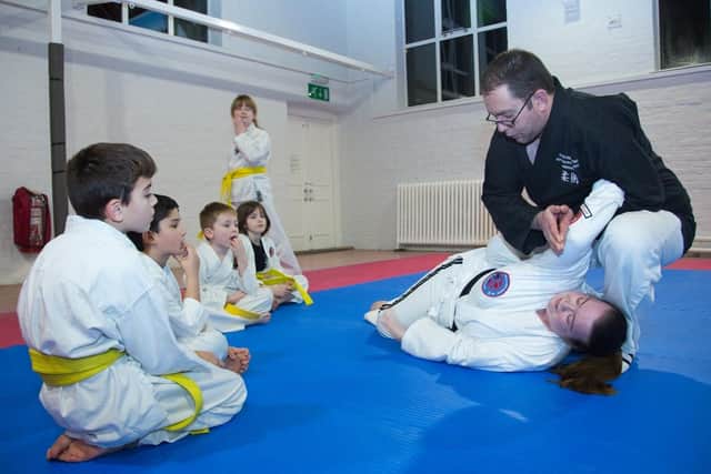 Demonstrating the knee-on-belly grappling position