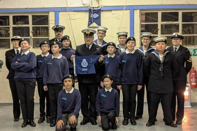 Lt (SCC) Brian Osborne, commanding officer, presents the unit ship’s company with a Burgee, awarded for achievements throughout 2019