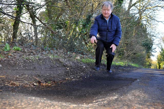 Phillip Winter in Hunters Race, West Lavant. Where a long stretch of the road was repaired but a deep pothole about three feet long in the middle of the repaired area wasn't treated and caused damage to his car. The area has now been filled in. Pic Steve Robards SR20021201