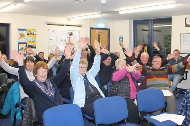 Littlehampton fundraisers demonstrate the distress signal used by sailors to catch people's attention. Picture: RNLI/Anthony Fogg