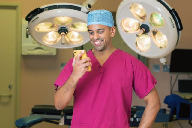 Surgeon Arun Ray, 33, at Worthing Hospital using the NHS Digital App, photo by Ian Stratton/NHS Digital