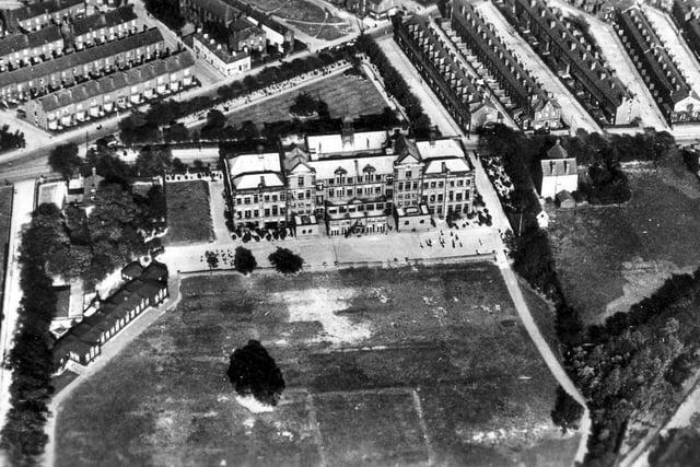 An undated aerial view. This shows the boys school. Town Street runs diagonally across the top left corner with Whingate running from left to right directly behind the school. On the left is Heights Lane separating the main playing field from the cricket field. On the corner of the field is the Kindergarten with the main school building in the centre.