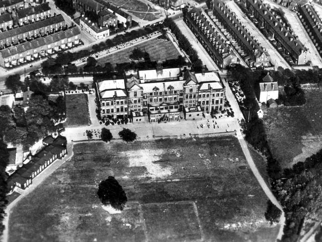 An undated aerial view. This shows the boys school. Town Street runs diagonally across the top left corner with Whingate running from left to right directly behind the school. On the left is Heights Lane separating the main playing field from the cricket field. On the corner of the field is the Kindergarten with the main school building in the centre.