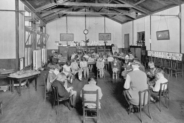 A room in the junior section of West Leeds High School, the only place in the school where boys and girls were permitted to mix. The children are all seated and reading. Circa 1940s.