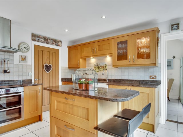 A well equipped kitchen with central island and breakfast bar
