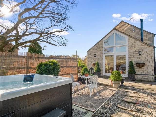 An enclosed patio and gravel area with a hot tub.
