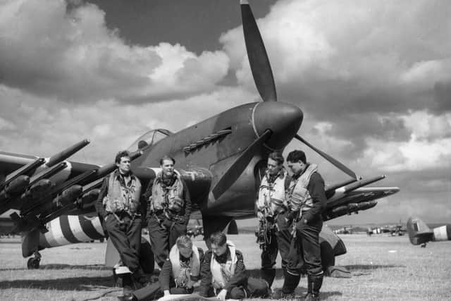 Pilots of No 198 Squadron RAF Second Tactical Air Force (123 Wing) study maps in front of their Hawker Typhoon IA fighter-bomber on June 16, 1944, at RAF Thorney Island (Photo by PNA Rota/Getty Images)