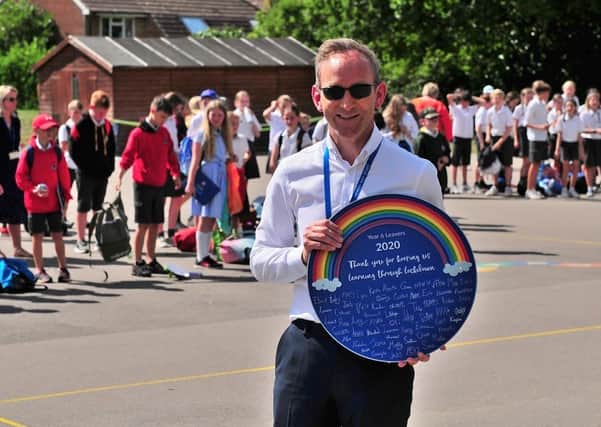 Parents of year-six pupils at Heron Way Primary School presented headteacher James Crump with a plaque to thank staff for keeping the children learning through lockdown. Picture: Charles Puckle SUS-200722-083458001