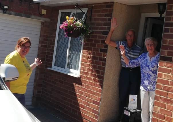 Volunteer Sarah Prater delivering a prescription to Hassocks residents, Ann and John Clifford