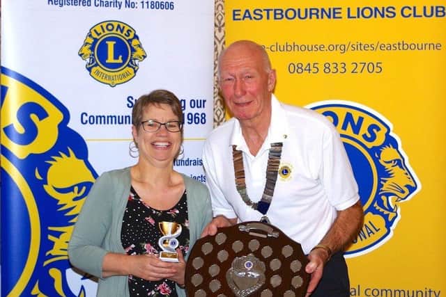Pat Messer receiving the Salvation Army trophy and shield from Lion President Alec
