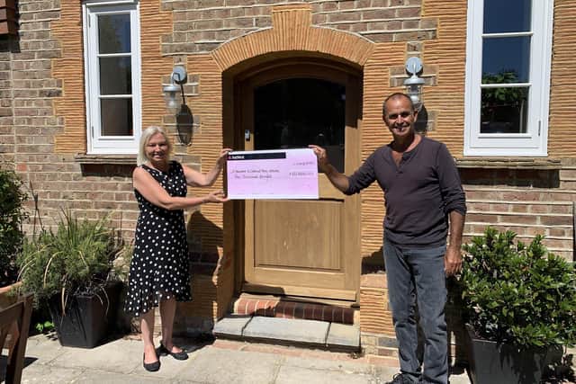 Peter Pearce presents an advance donation of £10,000 to Sarah Colbourne, head of fundraising at St Barnabas House in Worthing and Chestnut Tree House children's hospice near Arundel