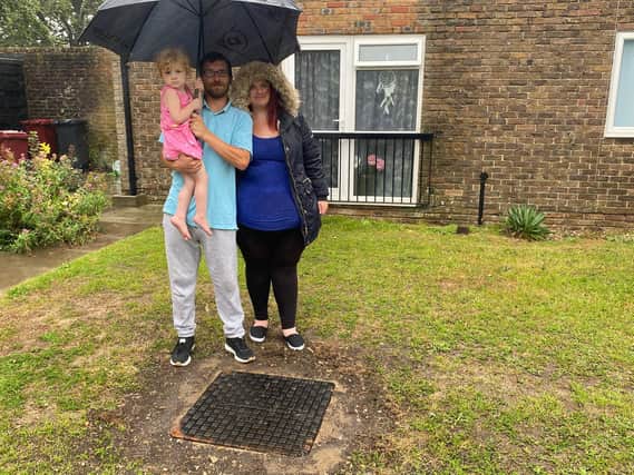 Amelia with her mother and father by the drain cover after it was replaced