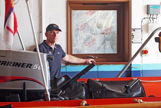 DM2090517a.jpg. Vandalism at Selsey Lifeboat Station. Rob Archibald, coxswain beside the broken window. Photo by Derek Martin Photography SUS-200915-184312008