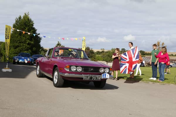 Kevin and Rachel Lawrence at Great Ballard School in their Triumph Stag, flagged away by new headmaster Matthew King and his family. Picture: Mick Briggs