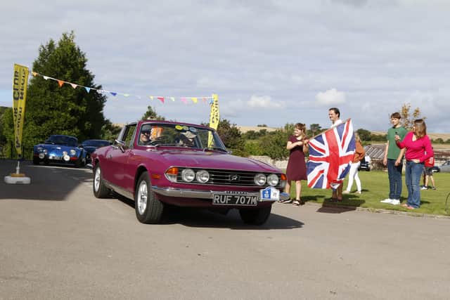 Kevin and Rachel Lawrence at Great Ballard School in their Triumph Stag, flagged away by new headmaster Matthew King and his family. Picture: Mick Briggs