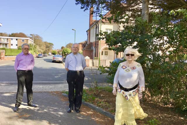 A Littlehampton priest has been without internet and a phone connection for weeks due to a damaged line. Pictured left to right: Paul Peppard, Father Carl Davies, Cate Peppard, in front of the telegraph pole that was damaged by tree overgrowth