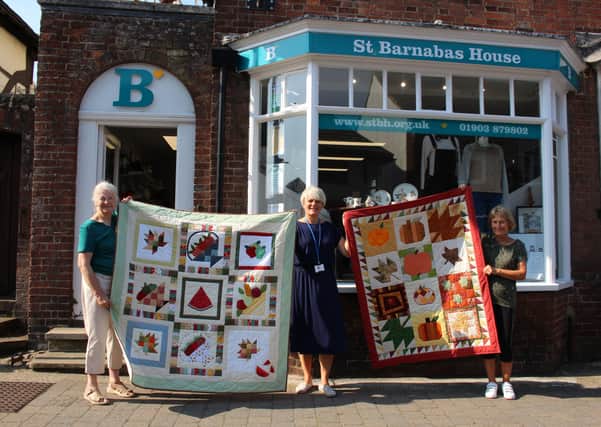 Quilter Sandi Dibb, Steyning's St Barnabas House shop manager Marianne Eyre, and quilter Linda Atkin with the two donated quilts SUS-200930-102318001