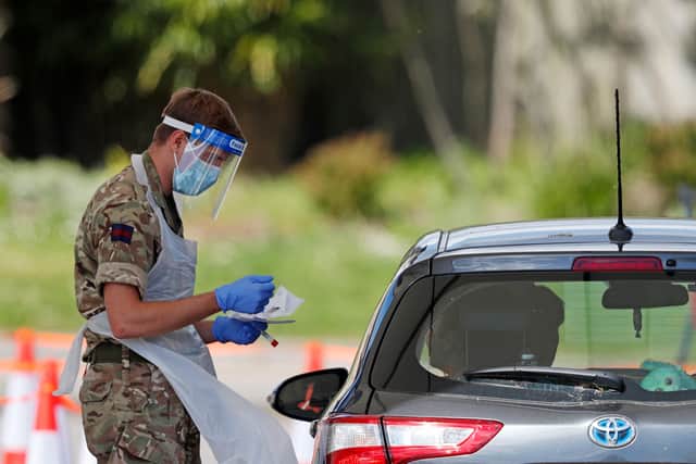 A member of the armed forces takes a swab to test for the novel coronavirus COVID-19 (Photo by Adrian DENNIS / AFP) (Photo by ADRIAN DENNIS/AFP via Getty Images)